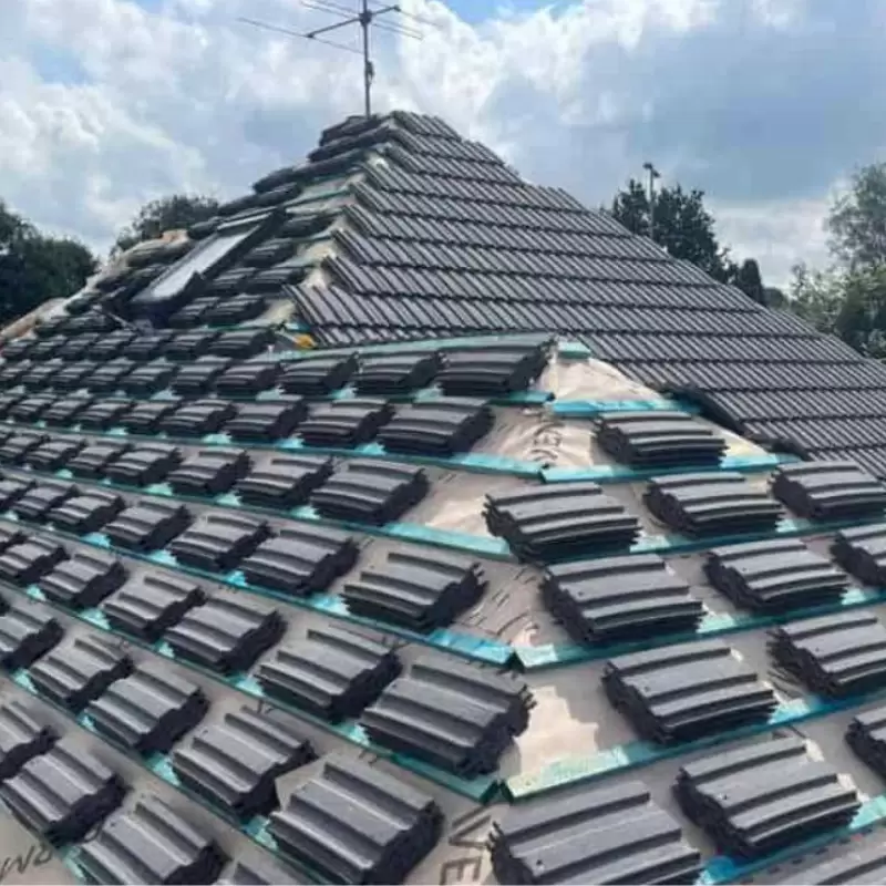 a roof being tiled with roof tiles positioned ready