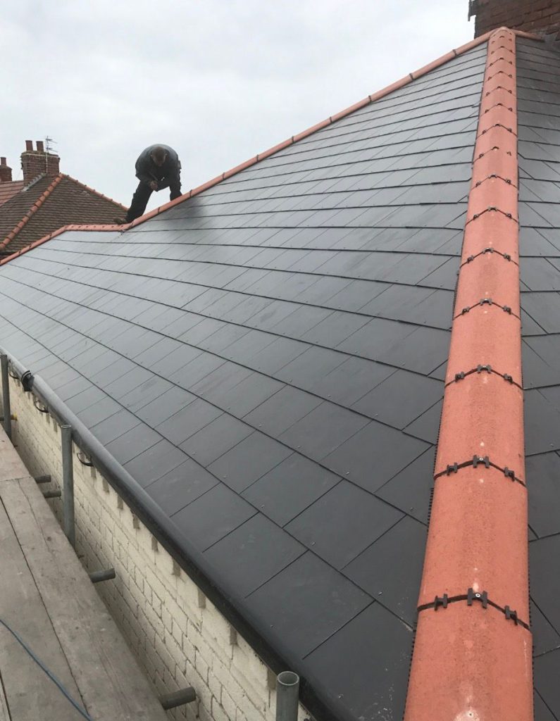 Contractor adding finishing touches to a new roof in Cheltenham